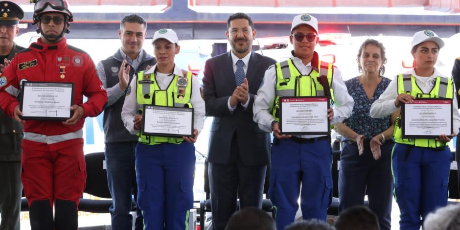 El titular de la SSC, Omar García Harfuch, y el mandatario capitalino, Martí Batres, detrás de los rescatistas que recibieron reconocimientos, ayer.
