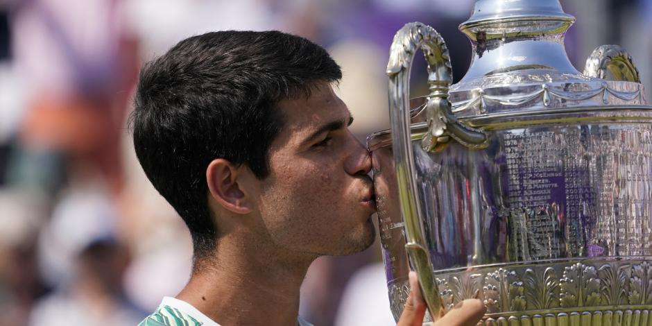 Carlos Alcaraz besa el trofeo tras derrotar a Alex de Miñaur en la final del torneo del Queen's Club, el domingo 25 de junio de 2023, en Londres.
