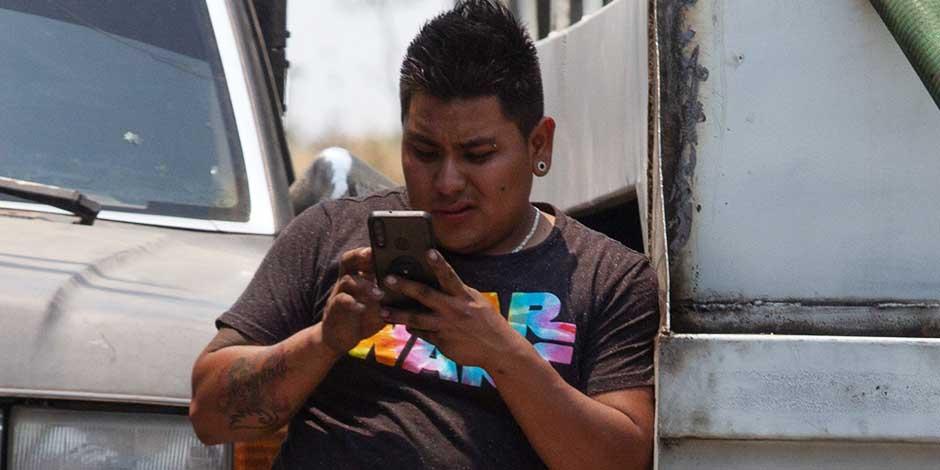 En esta imagen ilustrativa, un joven observa su celular en la alcaldía Iztapalapa