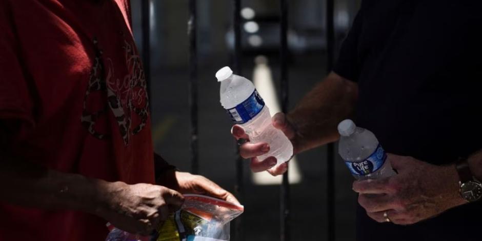 Un miembro de Star of Hope, una organización benéfica, reparte agua a personas sin hogar durante un período de clima cálido en Houston, Texas.