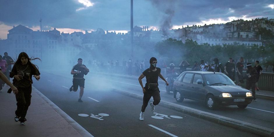 Manifestantes embozados huyen al enfrentar a la policía, ayer, en la ciudad de Lyon, Francia.