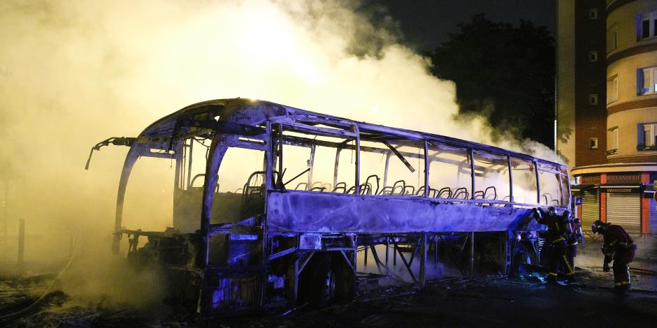 Bomberos arrojan agua a un autobús quemado, el sábado 1 de julio de 2023, en Nanterre, en las afueras de París, Francia.