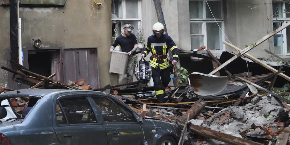 Un bombero ayuda a un ciudadano a recuperar sus pertenencias en un edificio bombardeado, ayer, en Sumi.