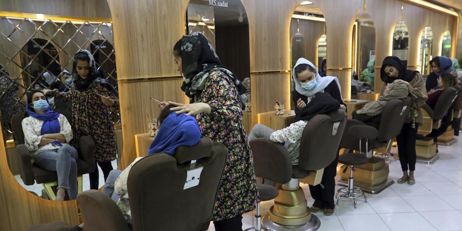 En esta imagen de archivo, varias empleadas maquillan a clientas en el salón de belleza Ms. Sadat, en Kabul, Afganistán, el 25 de abril de 2021.