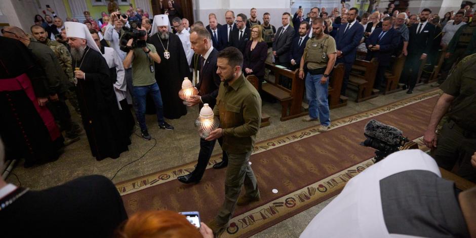 El presidente Volodimir Zelenski (de verde militar) y su homólogo polaco, Adrzej Duda, rinden homenaje a víctimas de crímenes, ayer.