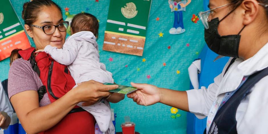 Una madre de familia se prepara para que su bebé sea vacunado en el Centro de Salud Rafael Ramírez, ayer.