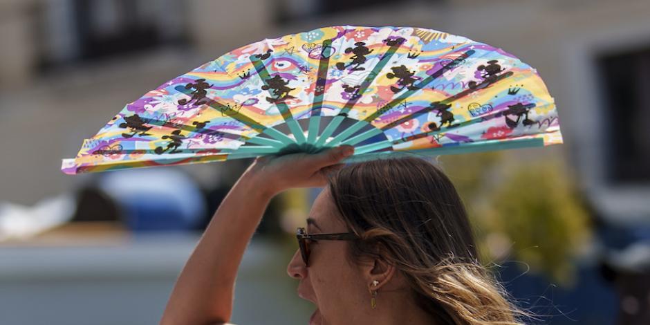 Una mujer se protege del rayo de sol con su abanico, ante el calor en España, ayer.
