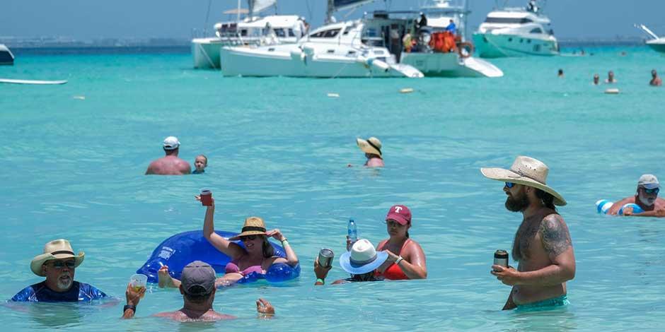Turistas disfrutan del mar en Isla Mujeres