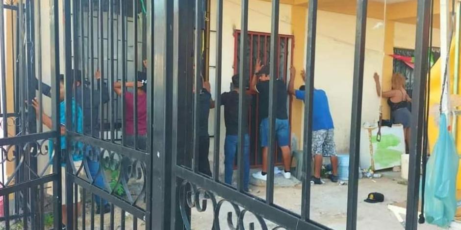 Varios adultos fueron puestos contra la pared para ser revisados durante el cateo realizado en una vecindad de Playa del Carmen en donde estaban los menores, ayer.