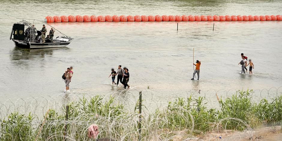 Migrantes intentan cruzar el río Bravo, ayer, donde Texas puso boyas.