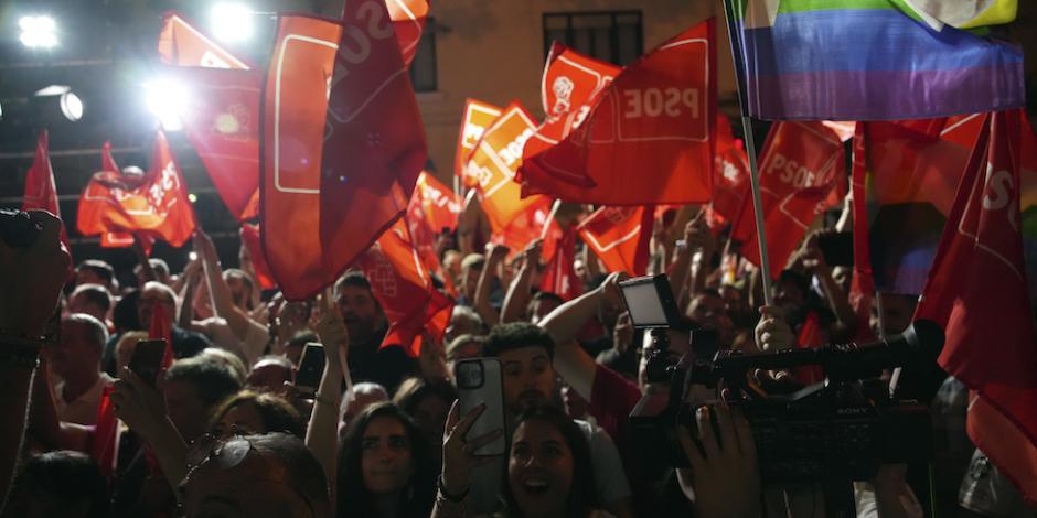 Simpatizantes del PSOE ondean banderas del actual partido en el gobierno tras la jornada electoral, ayer.