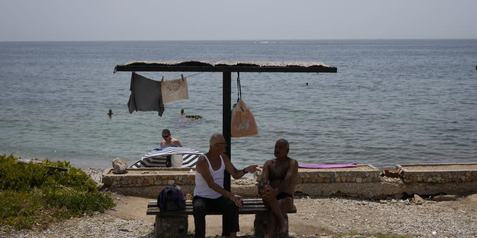 Residentes buscan la sombra en medio de temperaturas sofocantes en pleno verano en Grecia, ayer.
