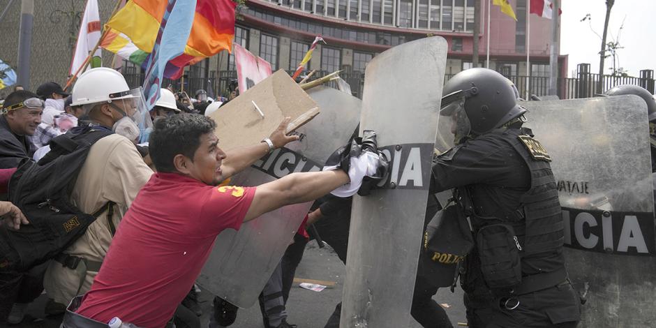 Manifestantes enfrentan a la policía, ayer, en Lima, a unas calles del Congreso.