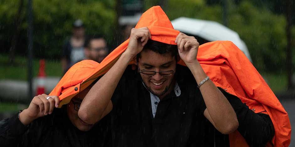 Capitalinos se cubren con lo que pueden de la intensa lluvia registrada en la alcaldía Miguel Hidalgo. 