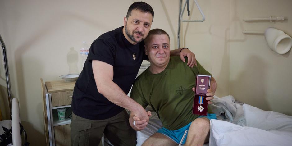 El presidente Volodimir Zelenski (izq.) entrega la medalla al valor a un soldado herido en batalla, ayer, en un hospital en Ivano-Frankivsk.