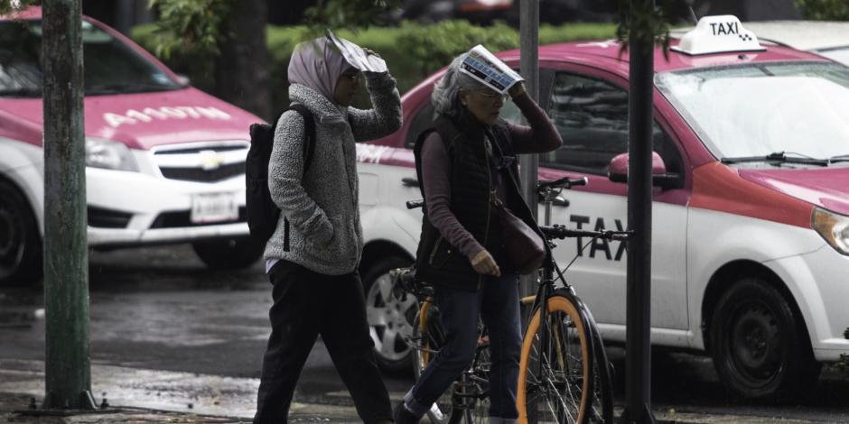 Lluvias leves se registran en toda la ciudad. En la imagen personas resguardandose de la lluvia en Av. Insurgentes.
FOTO: ANDREA MURCIA /CUARTOSCURO.COM
