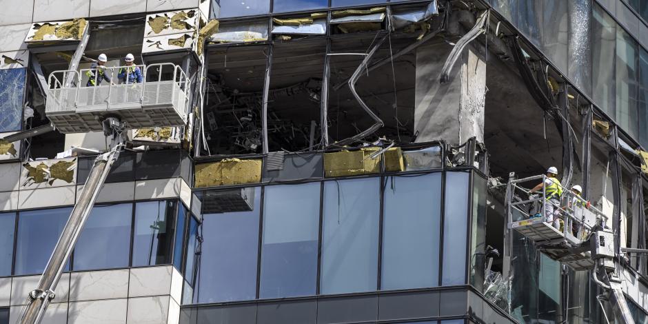 Los trabajadores de la grúa desmantelan los escombros de un rascacielos dañado en el distrito comercial de la "Ciudad de Moscú" después de un ataque con drones en Moscú, Rusia, el domingo 30 de julio de 2023.
