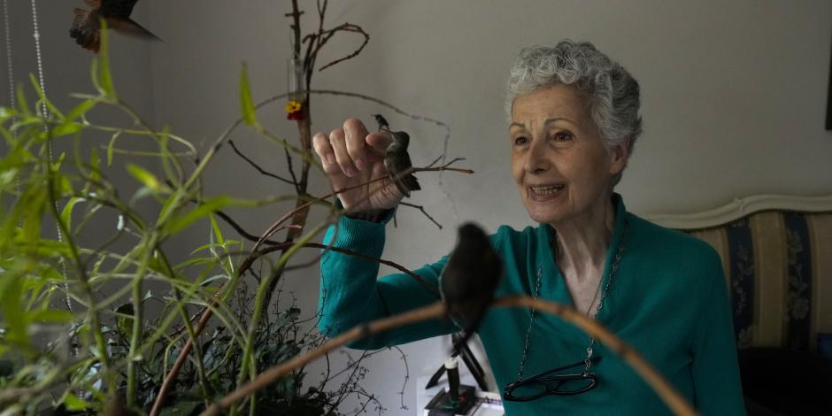 Catia Lattouf acaricia a un colibrí herido dentro de su apartamento que ha convertido en una clínica improvisada para estos pájaros en la CDMX