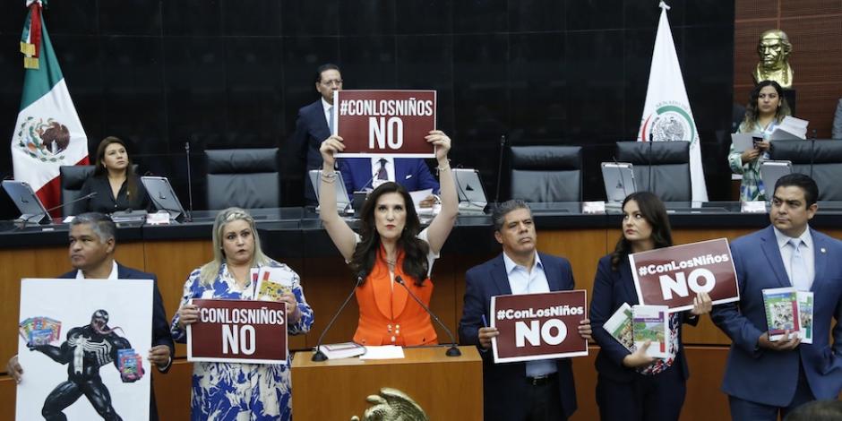 Legisladores exhibieron letreros con la leyenda #ConlosNiñosNo, ayer, en sesión.