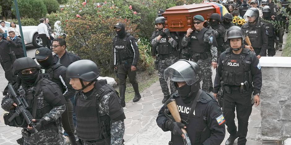 Los restos del candidato de Construye son trasladados por el cementerio en medio de custodia policial, ayer.