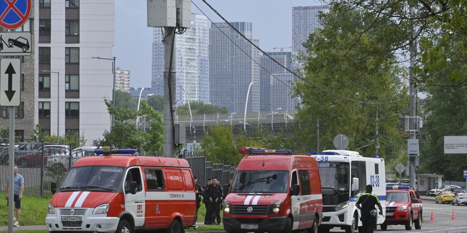 Vehículos policiales y de emergencias están estacionados al lado de los escombros de un dron caído cerca del terraplén Karamyshevskaya en Moscú, viernes 11 de agosto de 2023.
