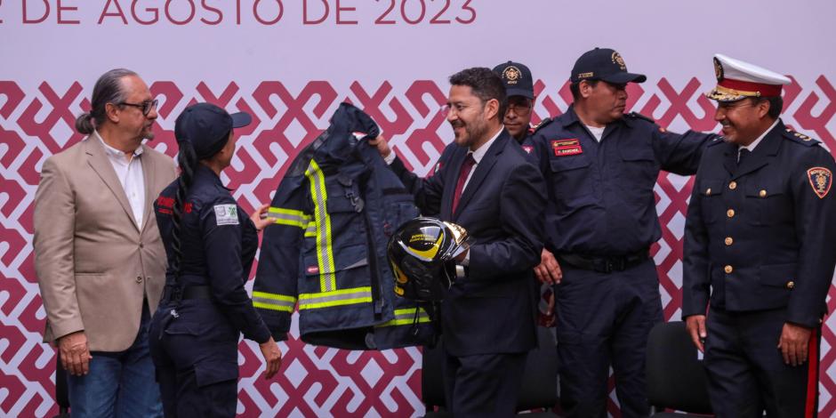 El Jefe de Gobierno, Martí Batres, entrega a una bombero su nuevo traje, ayer.