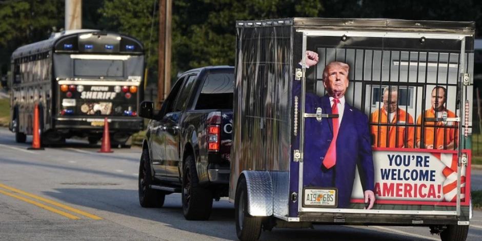 Un vehículo y un remolque pasan frente a la cárcel del condado de Fulton, el jueves 24 de agosto de 2023, en Atlanta. Está previsto la comparecencia de Trump ante las autoridades.
