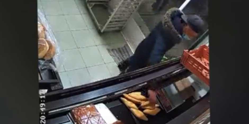 La imagen muestra el momento en que un ladrón toma un pan, después de robar en un comercio del Estado de México