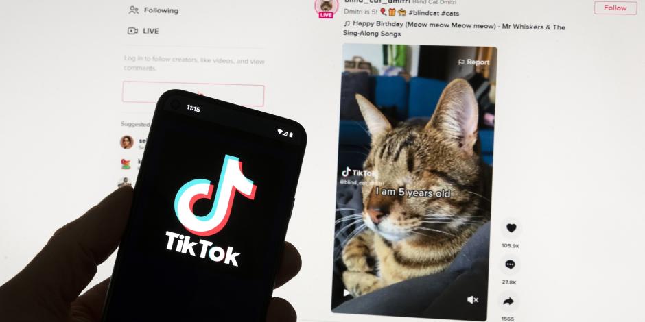 l logotipo de TikTok se ve en un teléfono móvil frente a una pantalla de computadora que muestra la pantalla de inicio de TikTok, el 18 de marzo de 2023.