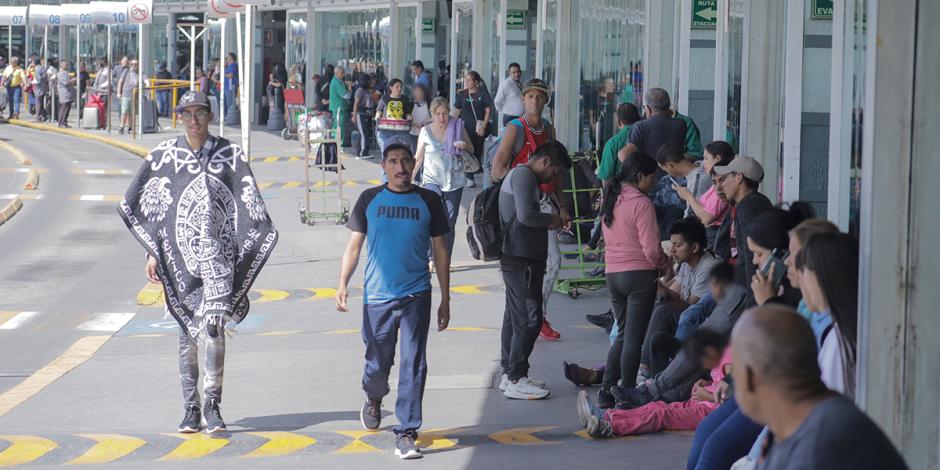 Migrantes esperan en el exterior de la Terminal de Autobuses del Norte, ayer.