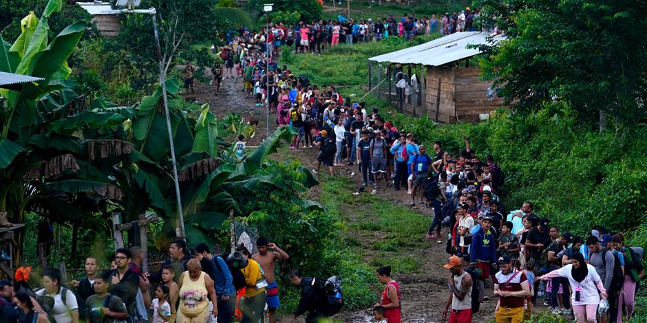 Migrantes que buscan llegar a Estados Unidos hacen fila para tomar un bote en Bajo Chiquito, en la provincia de Darién en Panamá