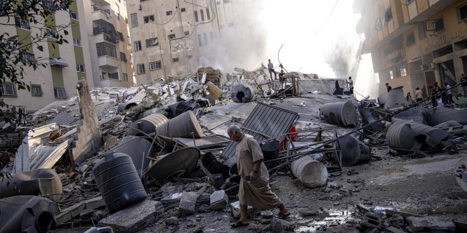 Palestinos inspeccionan los escombros de un edificio después de que fuera alcanzado por un ataque aéreo israelí en la ciudad de Gaza, el sábado 7 de octubre de 2023.