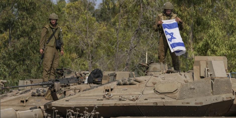 Soldados de Israel trabajan desde un tanque de guerra cerca de la frontera entre Israel y la Franja de Gaza, el lunes 9 de octubre.