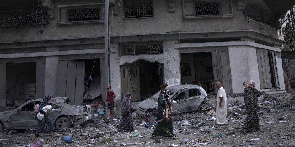 Palestinos caminan entre los escombros, tras los ataques aéreos, ayer.