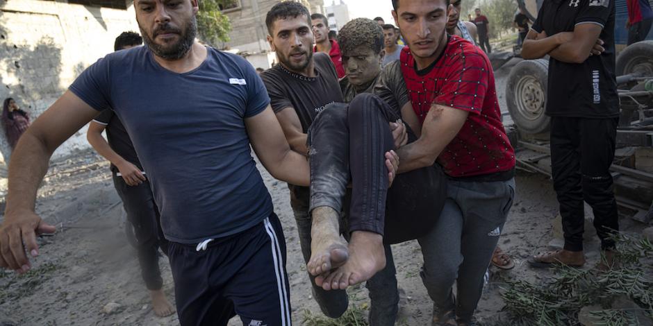 Ciudadanos ayudan a víctimas de los nuevos bombardeos en Gaza, ayer.
