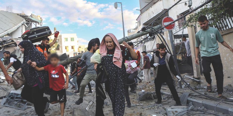 Familias palestinas salen corriendo de sus hogares después de los ataques aéreos israelíes, el martes.