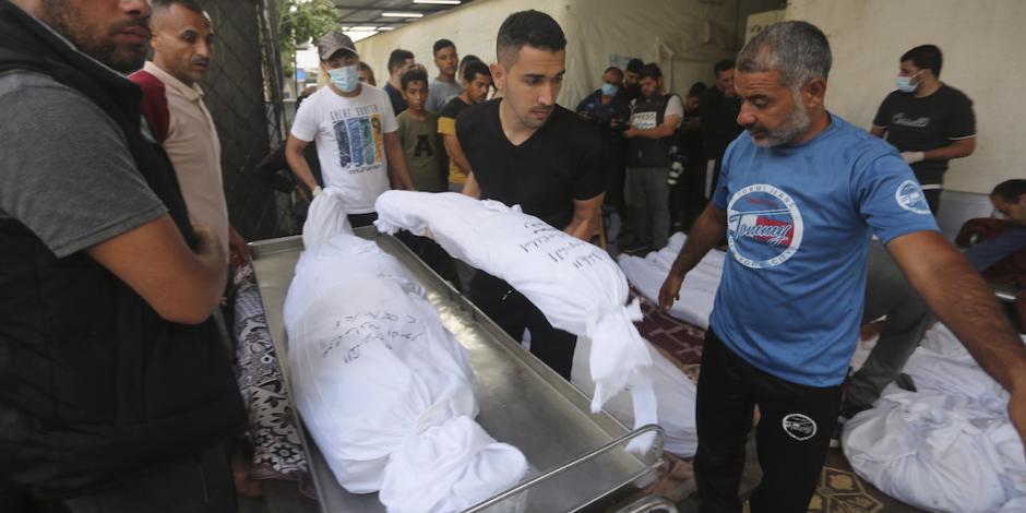 Palestinos acomodan los cuerpos de las recientes víctimas de bombardeos en su territorio, ayer.