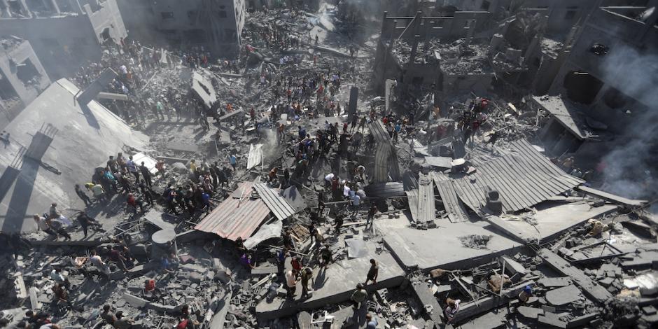 Decenas de palestinos se dividen para revisar debajo de escombros en un edificio bombardeado, ayer.
