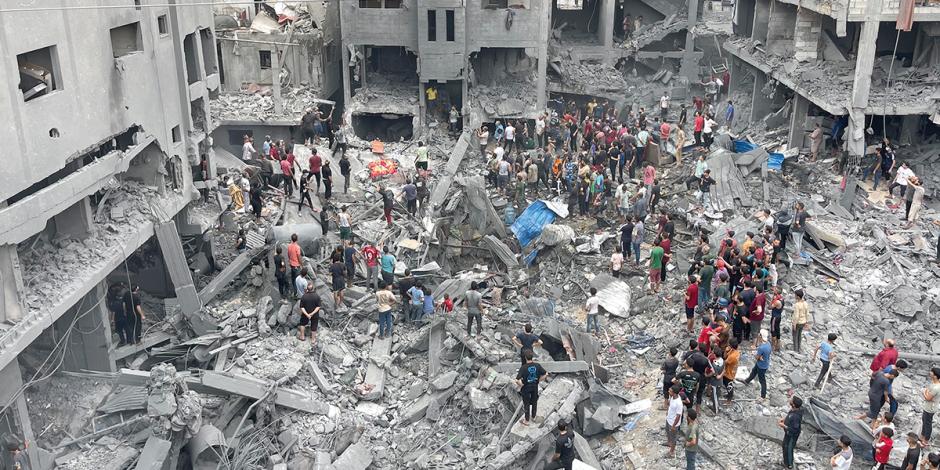 Palestinos inspeccionan restos de un edificio tras un bombardeo israelí, ayer.