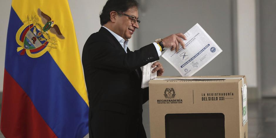 El mandatario colombiano coloca su boleta en una urna, ayer.