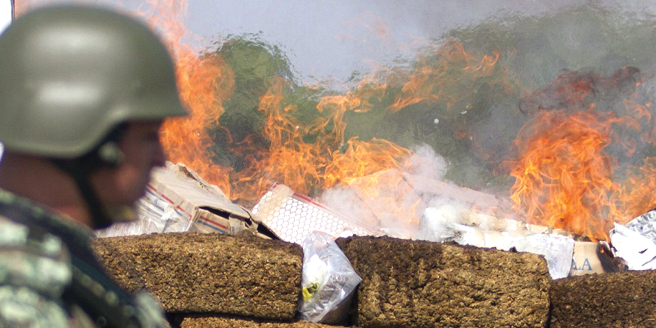 Un militar frente a más de una tonelada de narcóticos que están siendo incinerados, en octubre pasado.