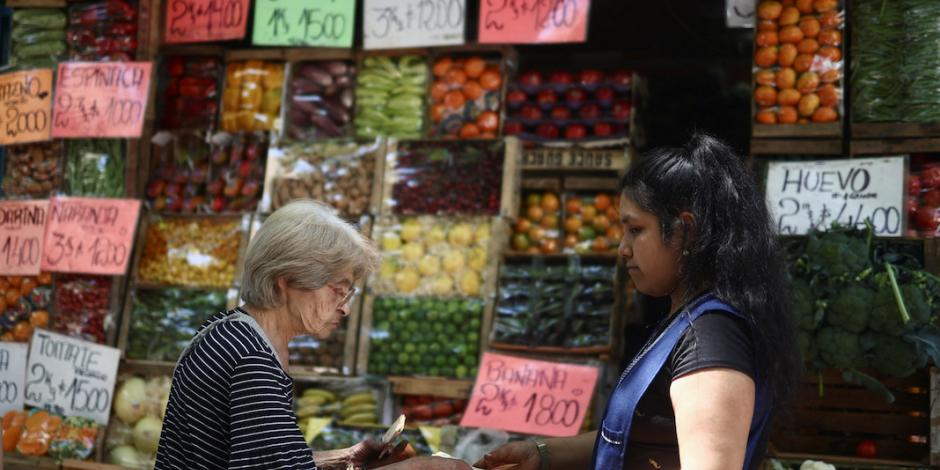 Una mujer compra fruta en un mercado de Buenos Aires, ayer.