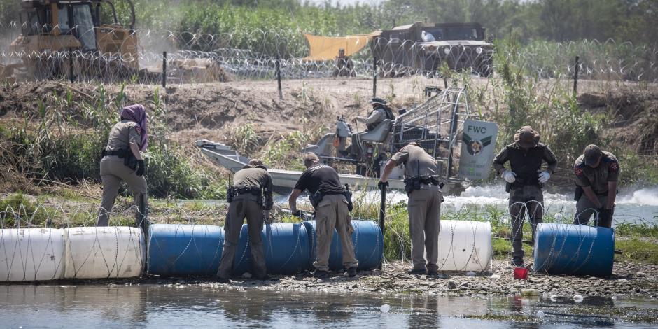 Policías de Texas colocan boyas con alambre de púas a lo largo del río Bravo, en la frontera con México.
