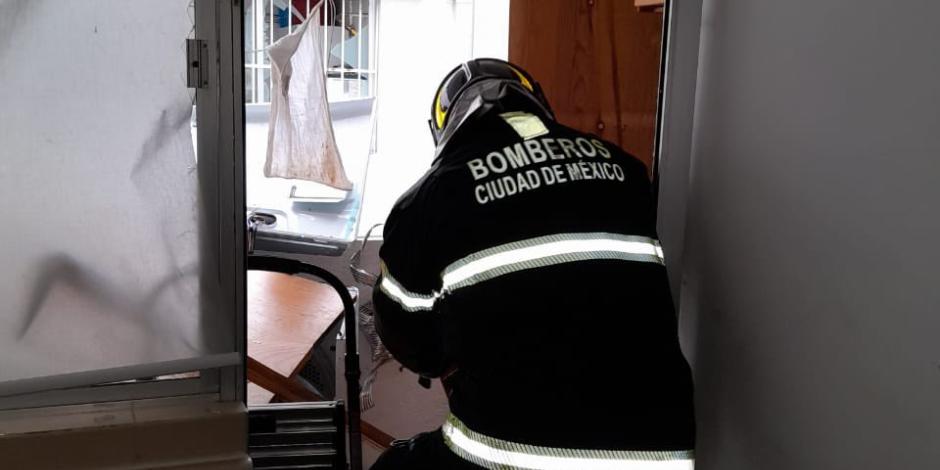 Un elemento del Cuerpo de Bomberos remueve escombros tras el incendio en una torre de departamentos, ayer.