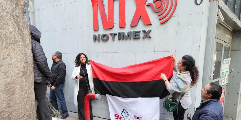 Integrantes del SUT Notimex retiran banderas en fin de la huelga. 