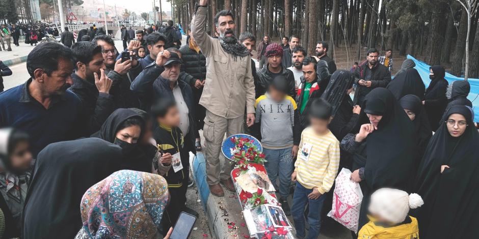 Residentes colocan ofrendas en honor a las víctimas caídas cerca del cementerio de Kerman, ayer.