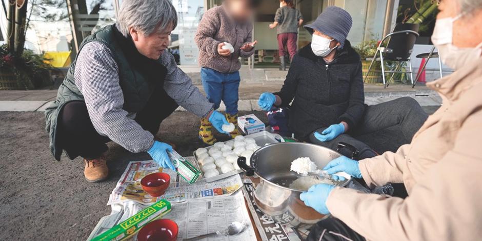 Ciudadanos se ayudan para preparar alimentos en la calle tras los potentes sismos, ayer.