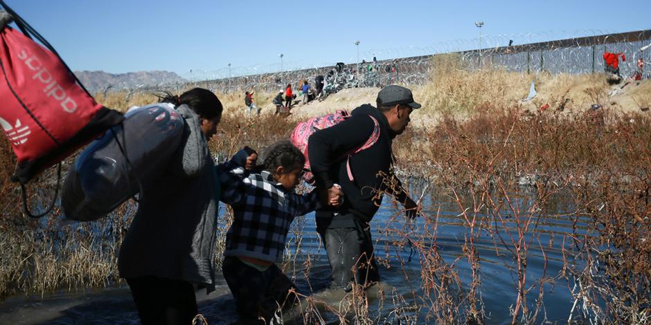 Una familia de migrantes cruza el río Bravo para llegar a EU, desde Ciudad Juárez, el 27 de diciembre.