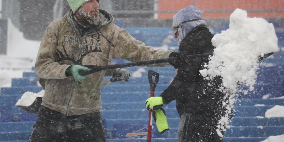 Seguidor de los Bills saca la nieve del estadio para el juego de hoy.
