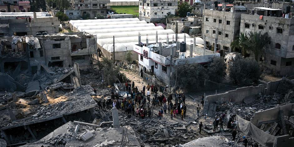 Residentes gazatíes caminan entre nuevos escombros provocados por otra ofensiva rival.